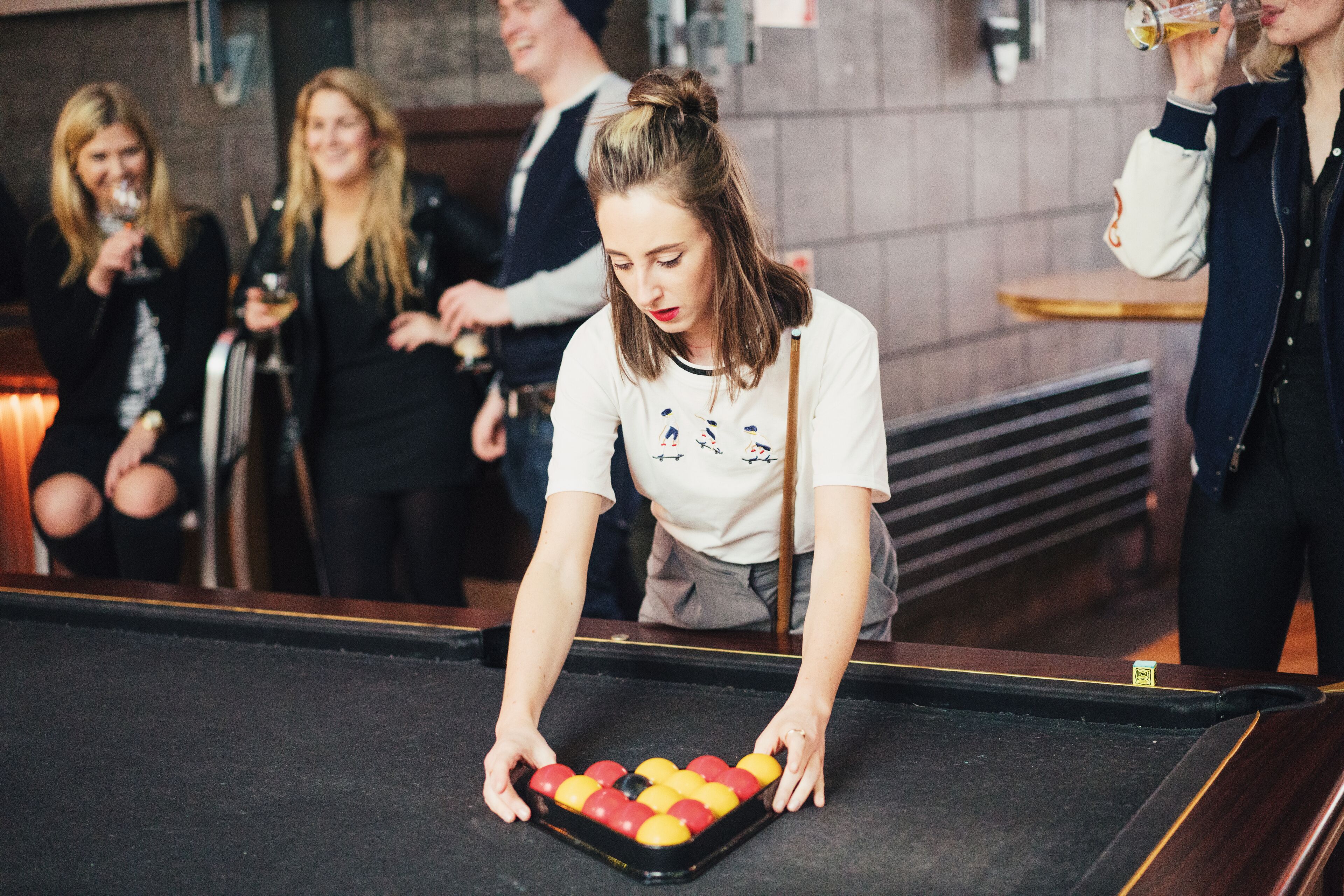A billiards table with balls and a cue stick.