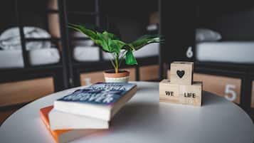 Une table bien rangée, sur laquelle on trouve un livre intitulé « Tous vos moments parfaits », une plante en pot et des blocs de bois formant les lettres « WE LIFE ».