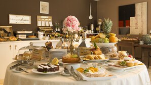 A buffet with various desserts and fruits, including cakes, pastries, and a pineapple.