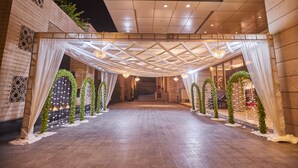 L’entrée d’un hôtel, avec une allée couverte, des arches décoratives et un lustre.