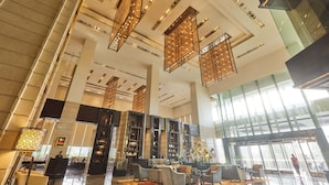 A spacious lobby with high ceilings, modern lighting fixtures, and a reception desk. - Crowne Plaza New Delhi Rohini by IHG (New Delhi)