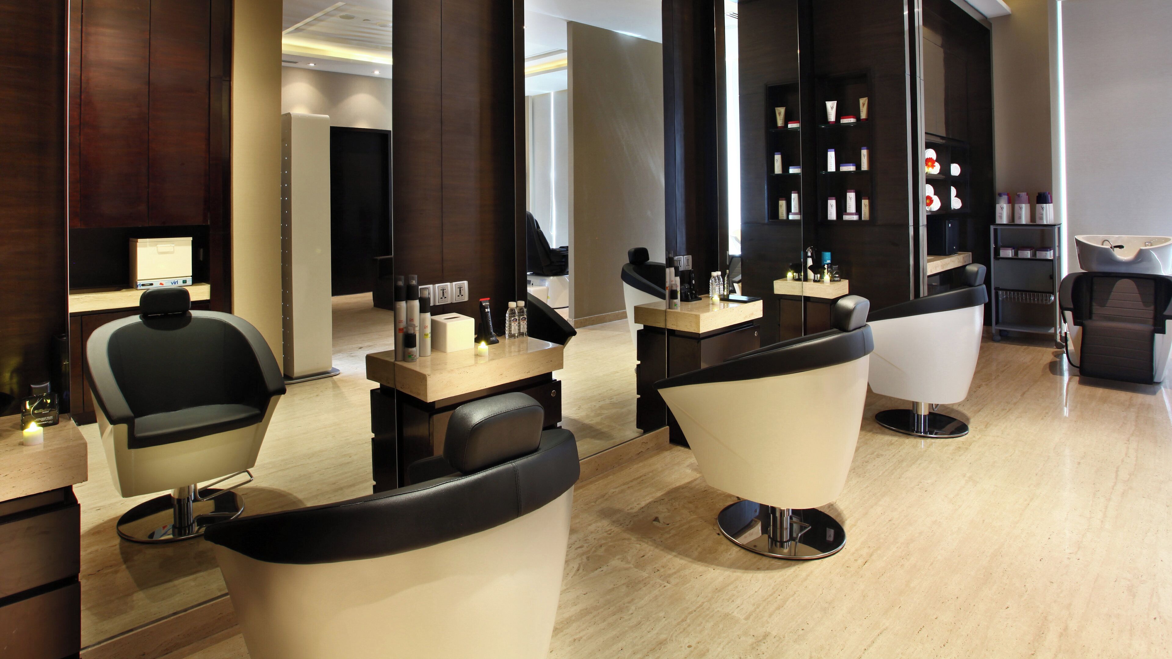 Ein zeitgemäßer Friseursalon mit mehreren Sitzbereichen, einer Rezeption und einer übersichtlichen Produktpräsentation.