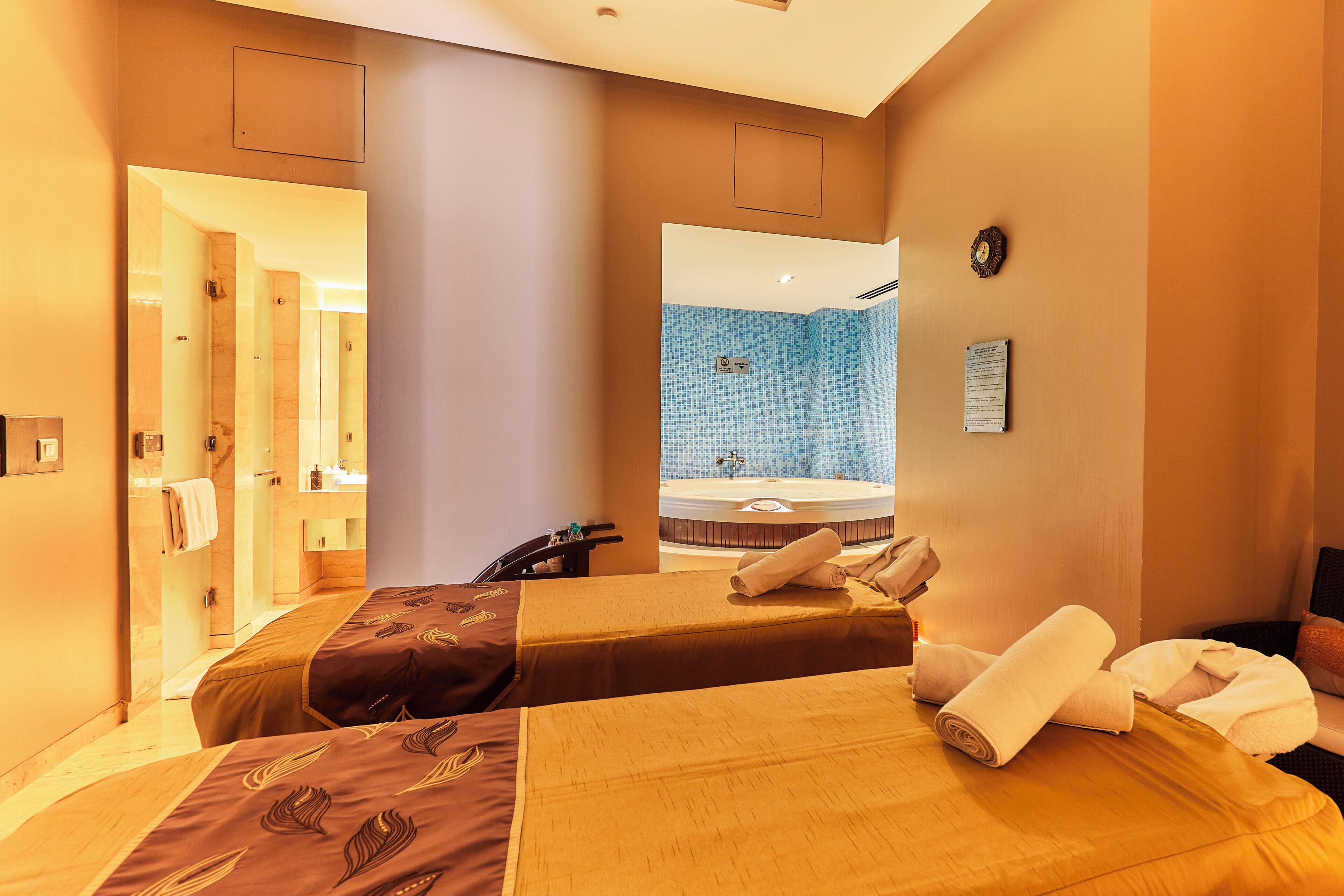 A hotel room with two beds, a bathroom, and a view of a pool area.