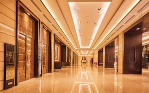 A hotel corridor with a polished floor, large doors, and a ceiling with recessed lighting. - Crowne Plaza New Delhi Rohini by IHG (New Delhi)