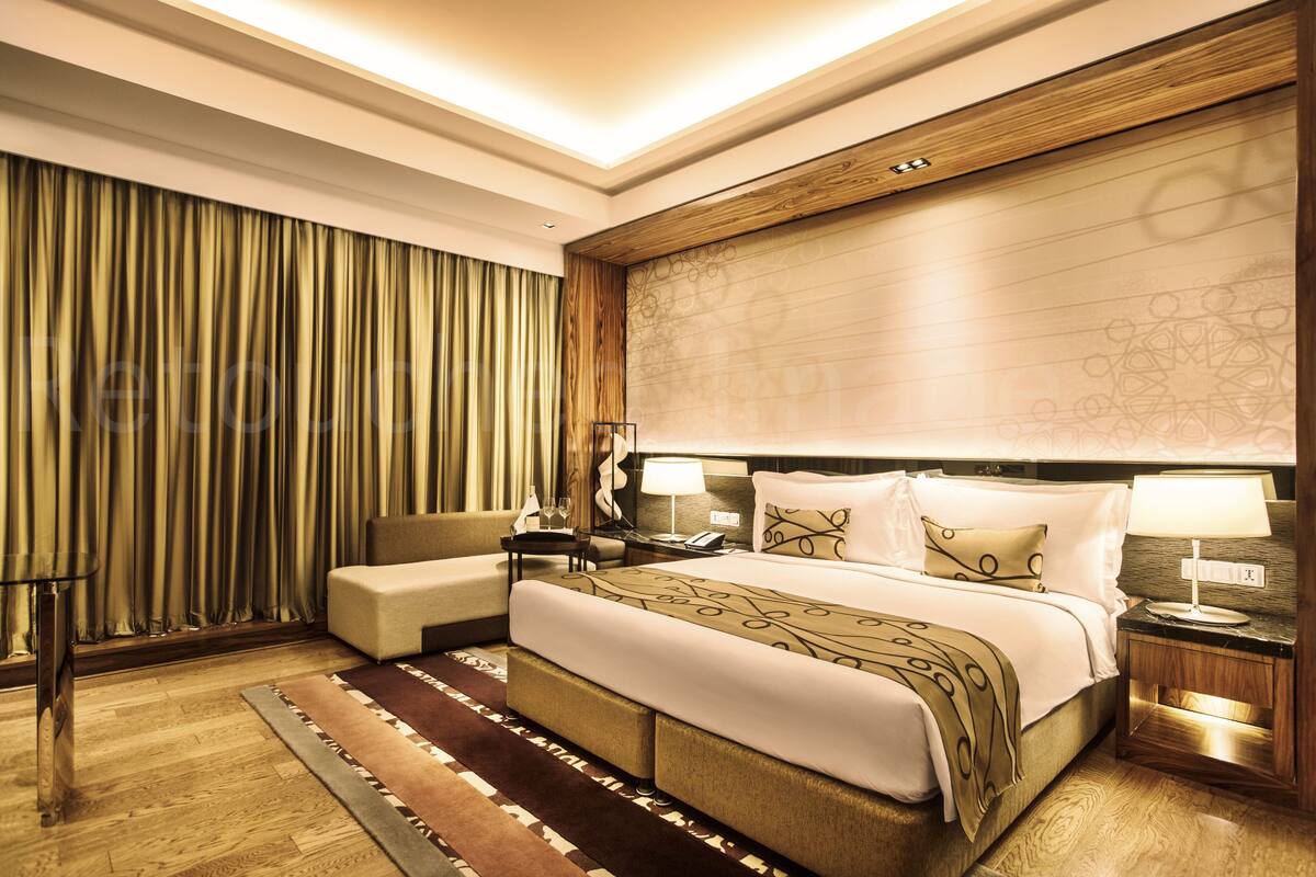 Una habitación de hotel moderna con una cama grande, una zona de estar y un escritorio.