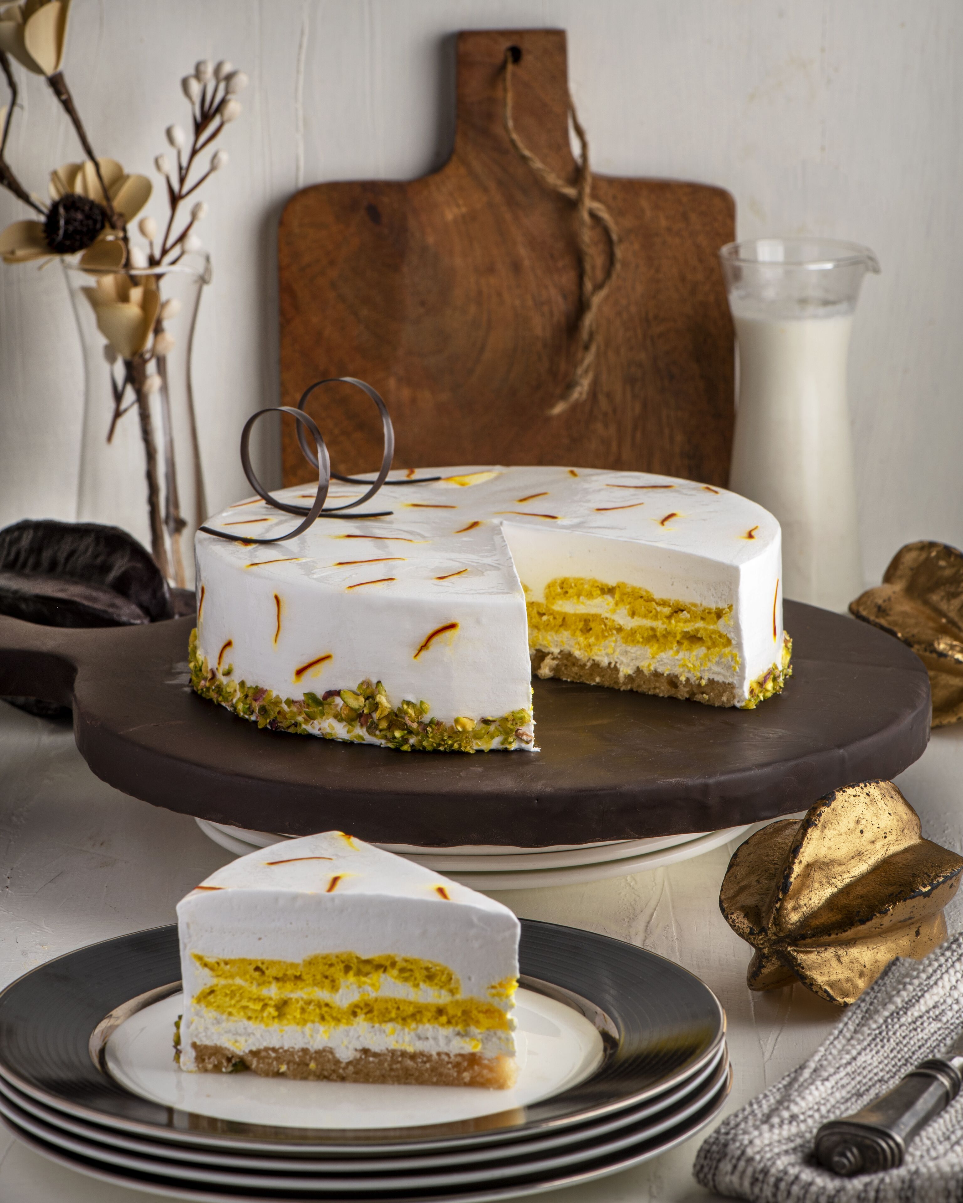 A cake with a slice cut out, placed on a dark wooden board.