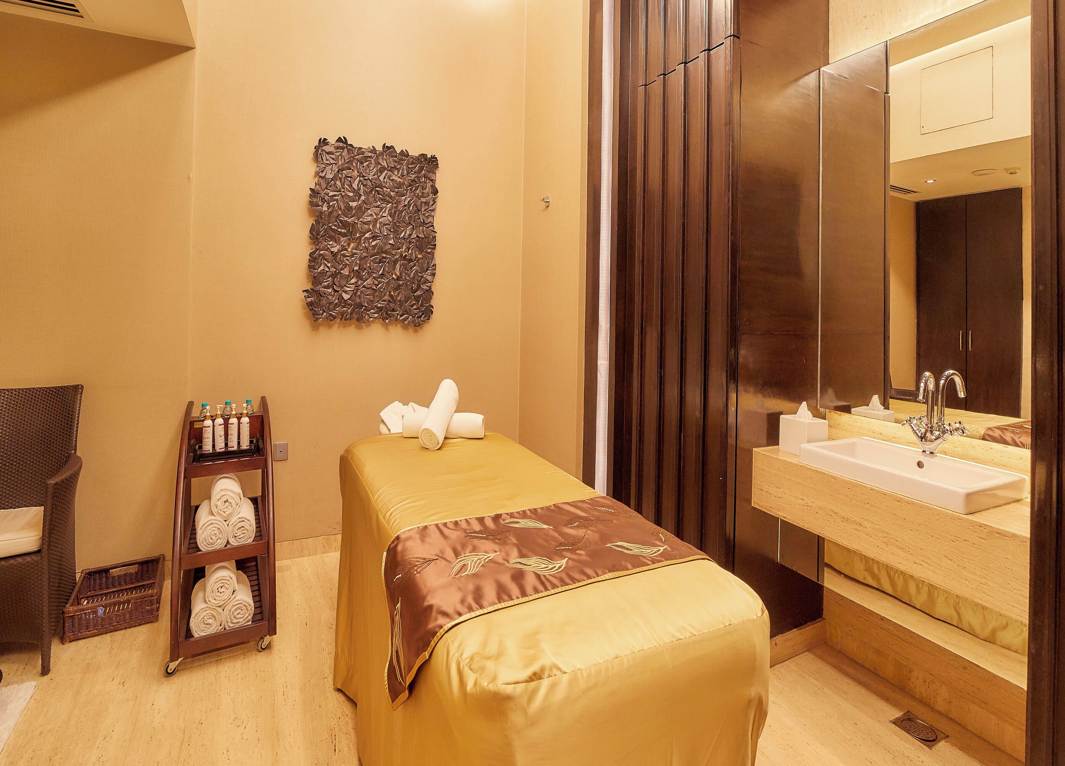 Une chambre d’hôtel avec un lit, une petite table avec des articles de toilette, un miroir et un plancher en bois.