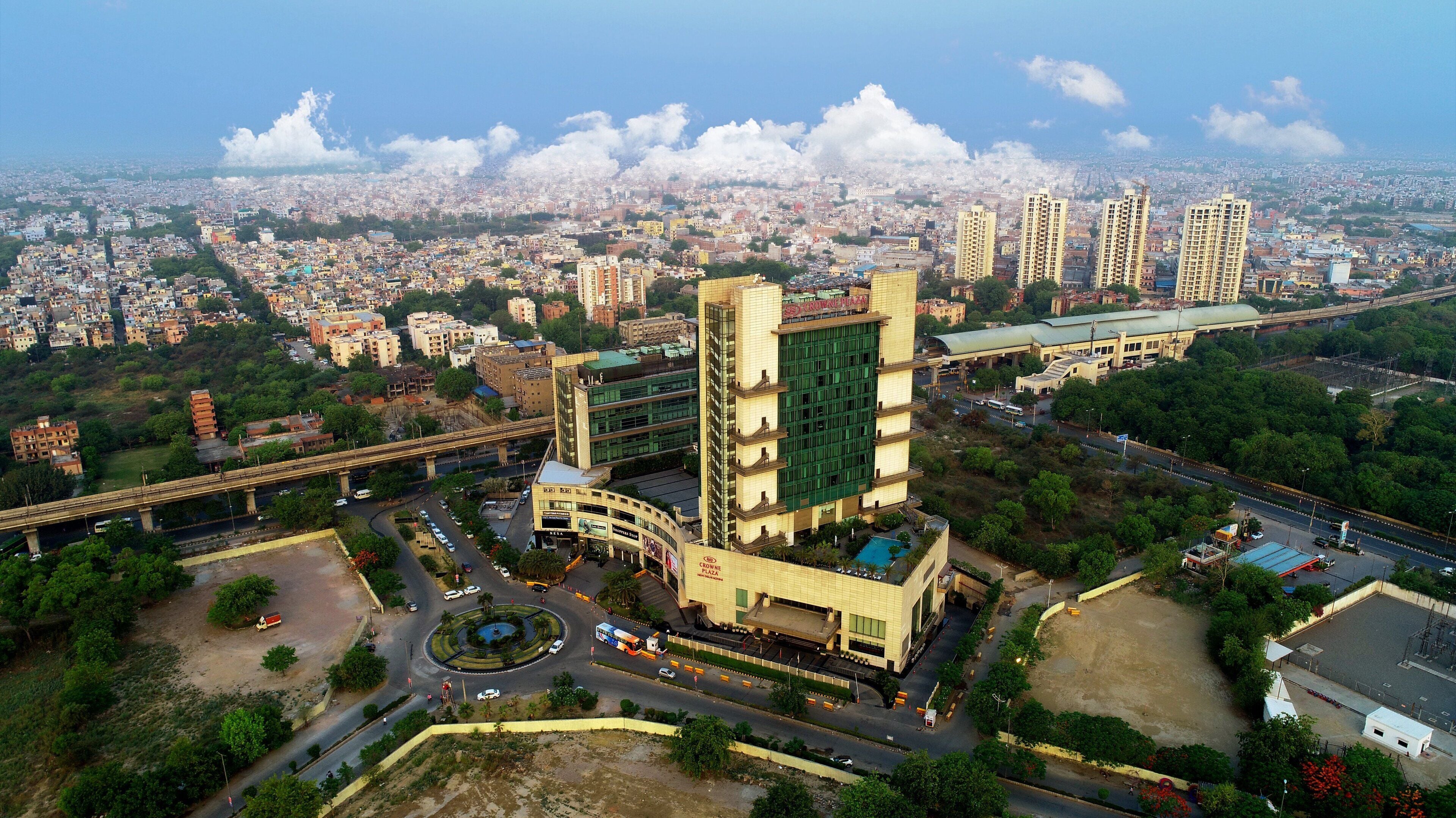 A high-rise building with a modern design, surrounded by a mix of residential and commercial buildings.