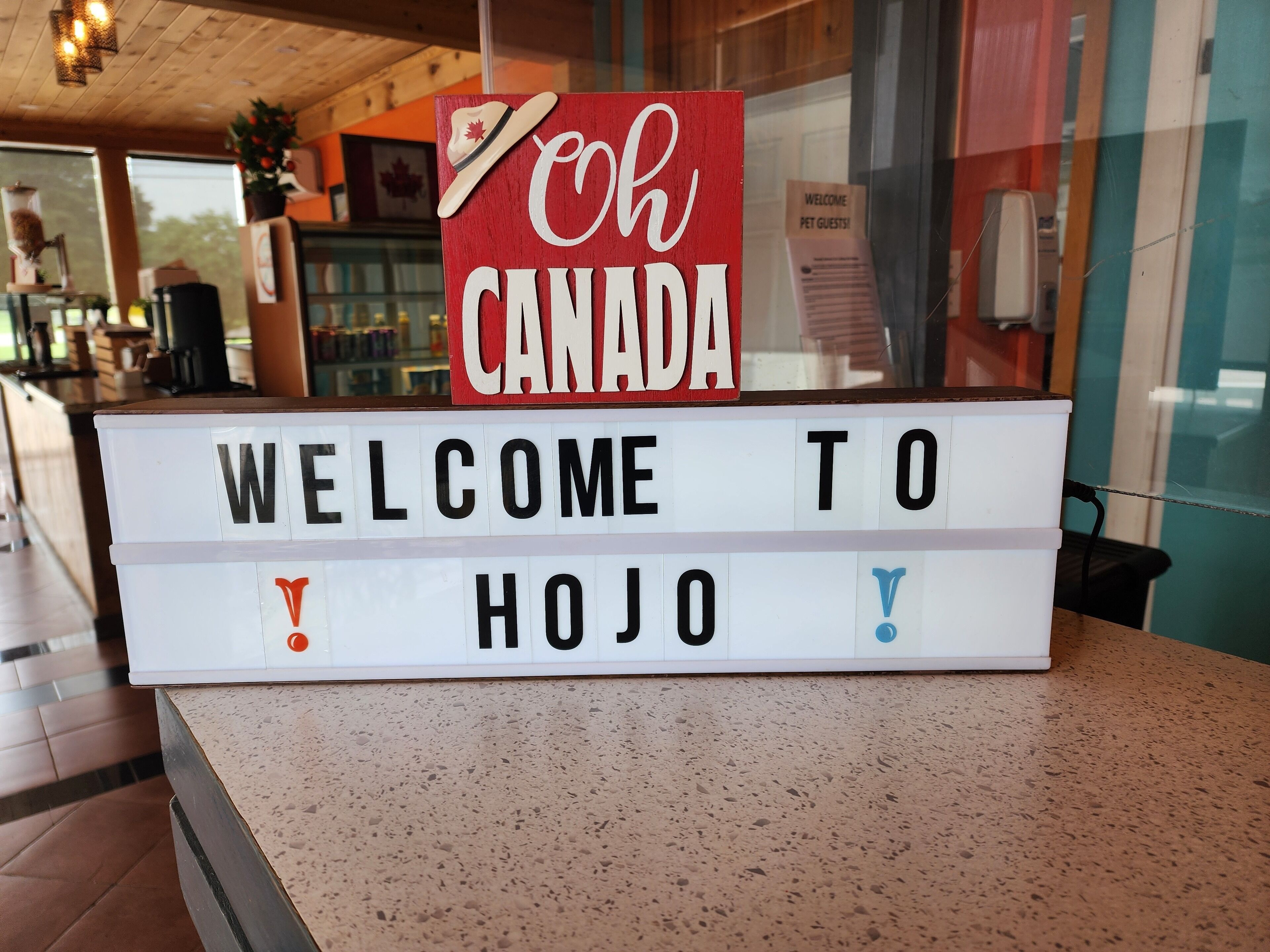 A welcome sign with "Welcome to Canada" and "Welcome to Hojo" on a lightbox display.