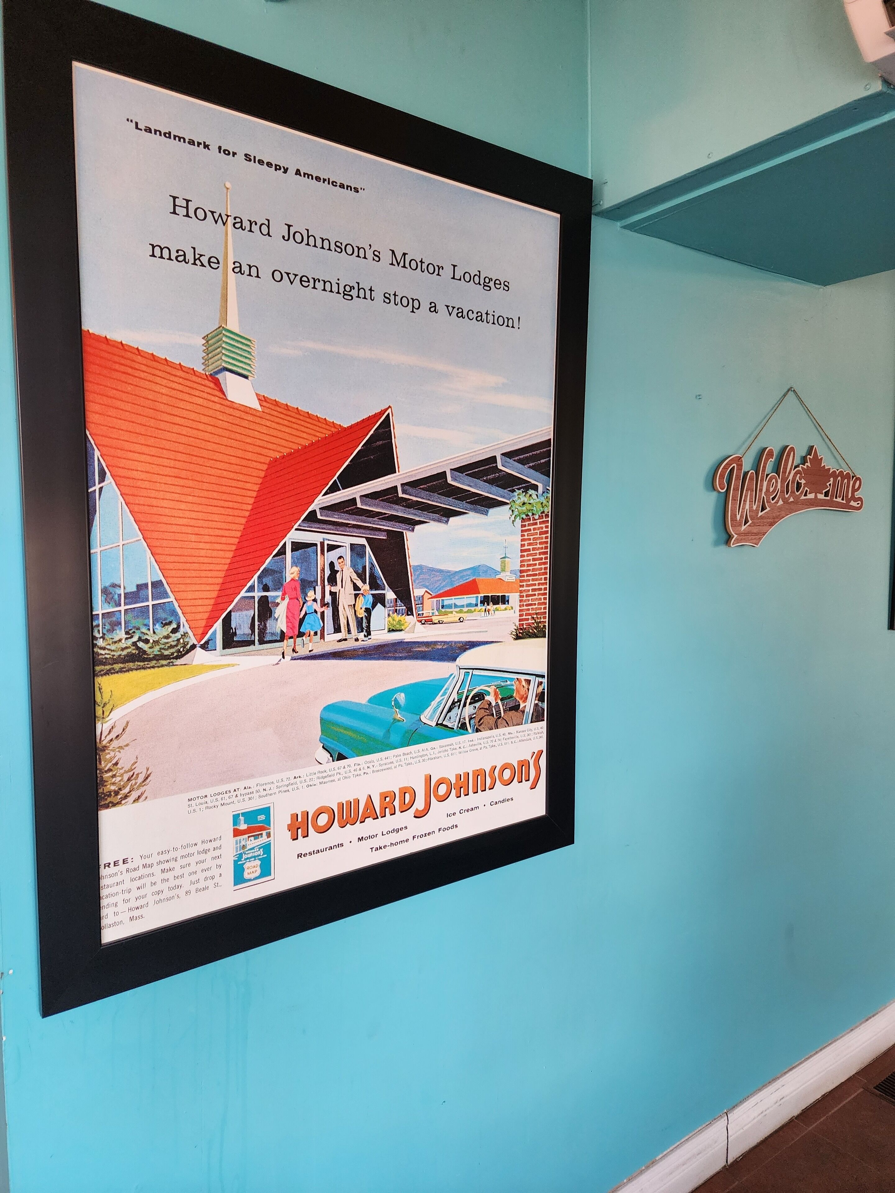 Een lijstadvertentie voor Howard Johnson's Motor Lodges, met een blauwe auto en een rode dakconstructie.