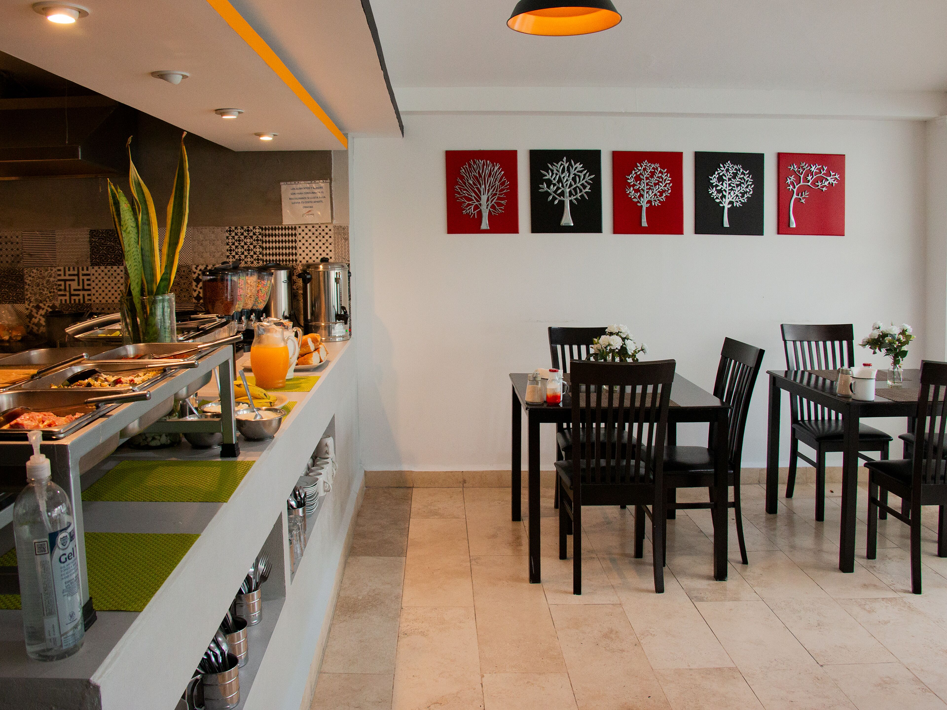 A breakfast buffet with various food options and a dining area with chairs and tables.