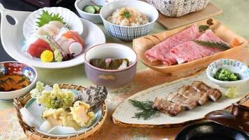 Variedad de platos japoneses dispuestos sobre una mesa, incluyendo sushi, sashimi y otras comidas tradicionales, con un fondo decorativo de flores de cerezo.
