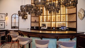 A bar area with a counter, multiple stools, and a patterned floor.