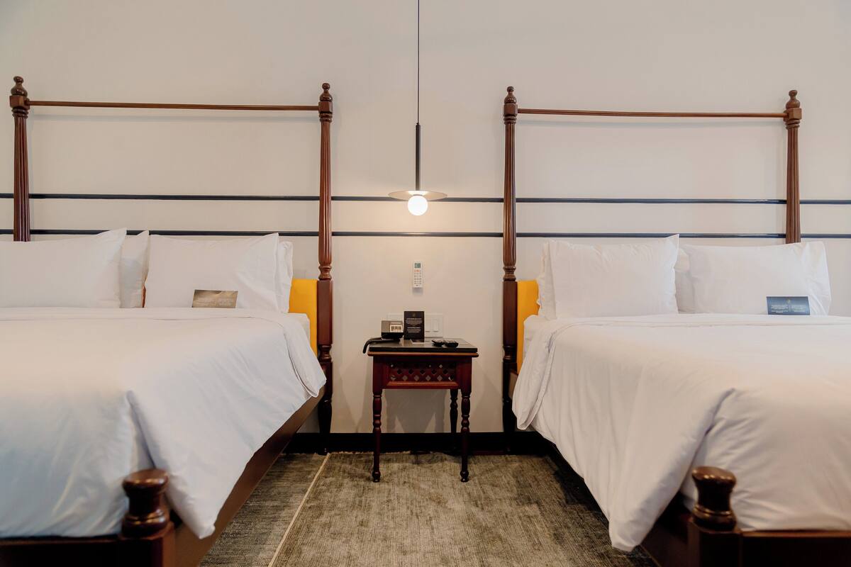 Une chambre double avec deux lits, une petite table et une table de chevet.