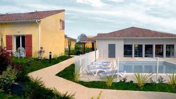 Une propriété résidentielle dotée d’une piscine, d’un patio couvert et d’un jardin.