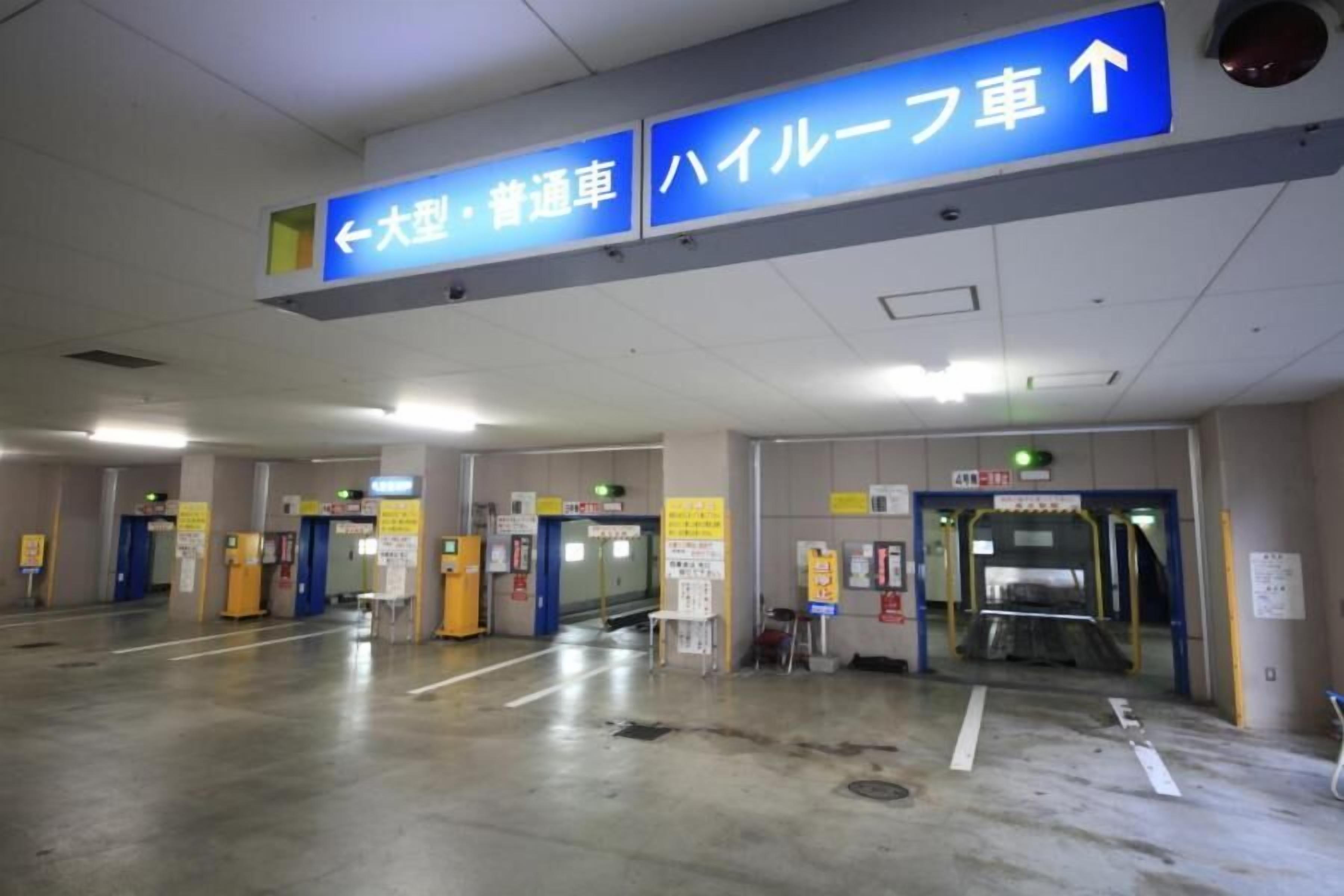 A parking garage with directional signs for large vehicles and buses.