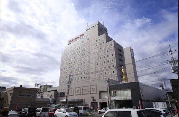 A multi-story hotel with a central courtyard and a statue on the rooftop. - Kofu Washington Hotel Plaza (Kofu)