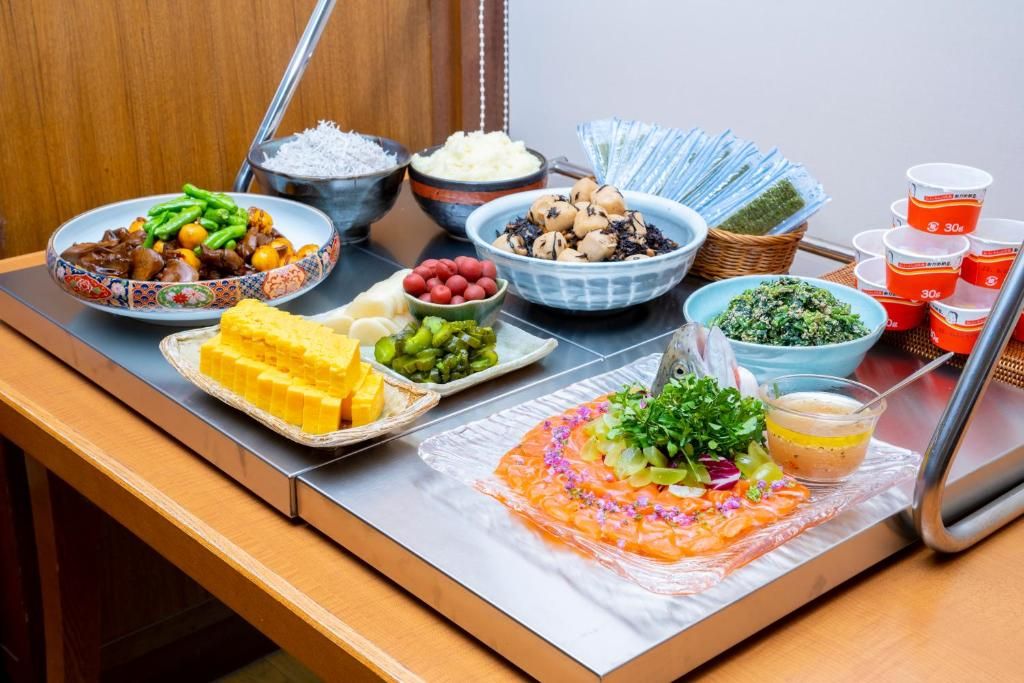 A buffet table with various dishes, including a salmon dish, salads, and other prepared foods.