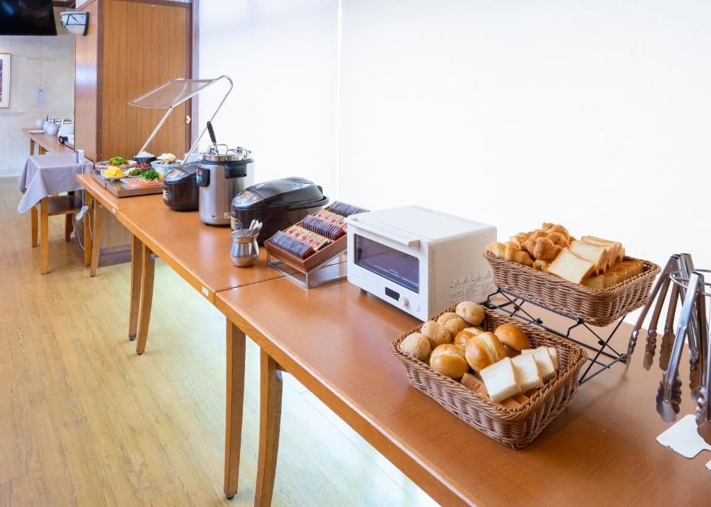 Un buffet proposant divers plats, une machine à café et un four à micro-ondes.