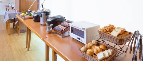 Un buffet proposant divers plats, une machine à café et un four à micro-ondes.