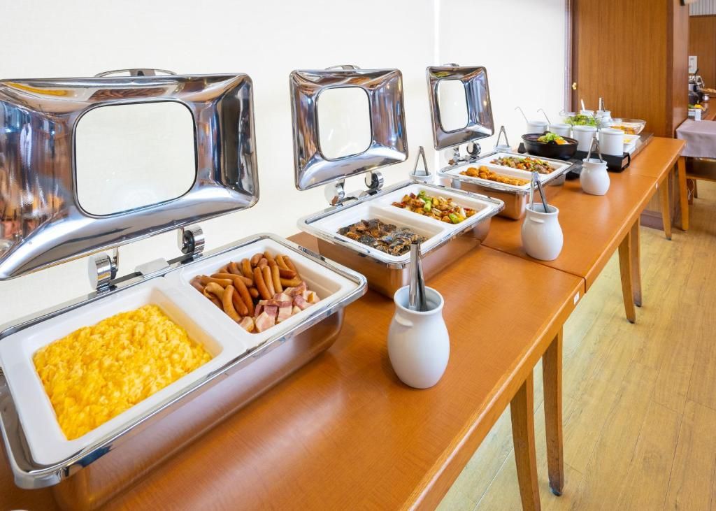 A buffet setup with various food items and serving utensils.