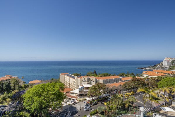 A coastal town with buildings, a road, and a view of the sea.