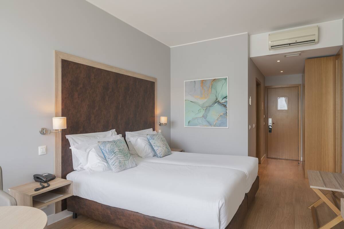 Une chambre d’hôtel avec un grand lit, des tables de chevet, un bureau et une chaise.