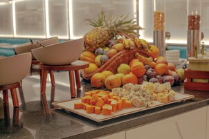 En morgenmadsbuffet med frugt og oste på en disk.