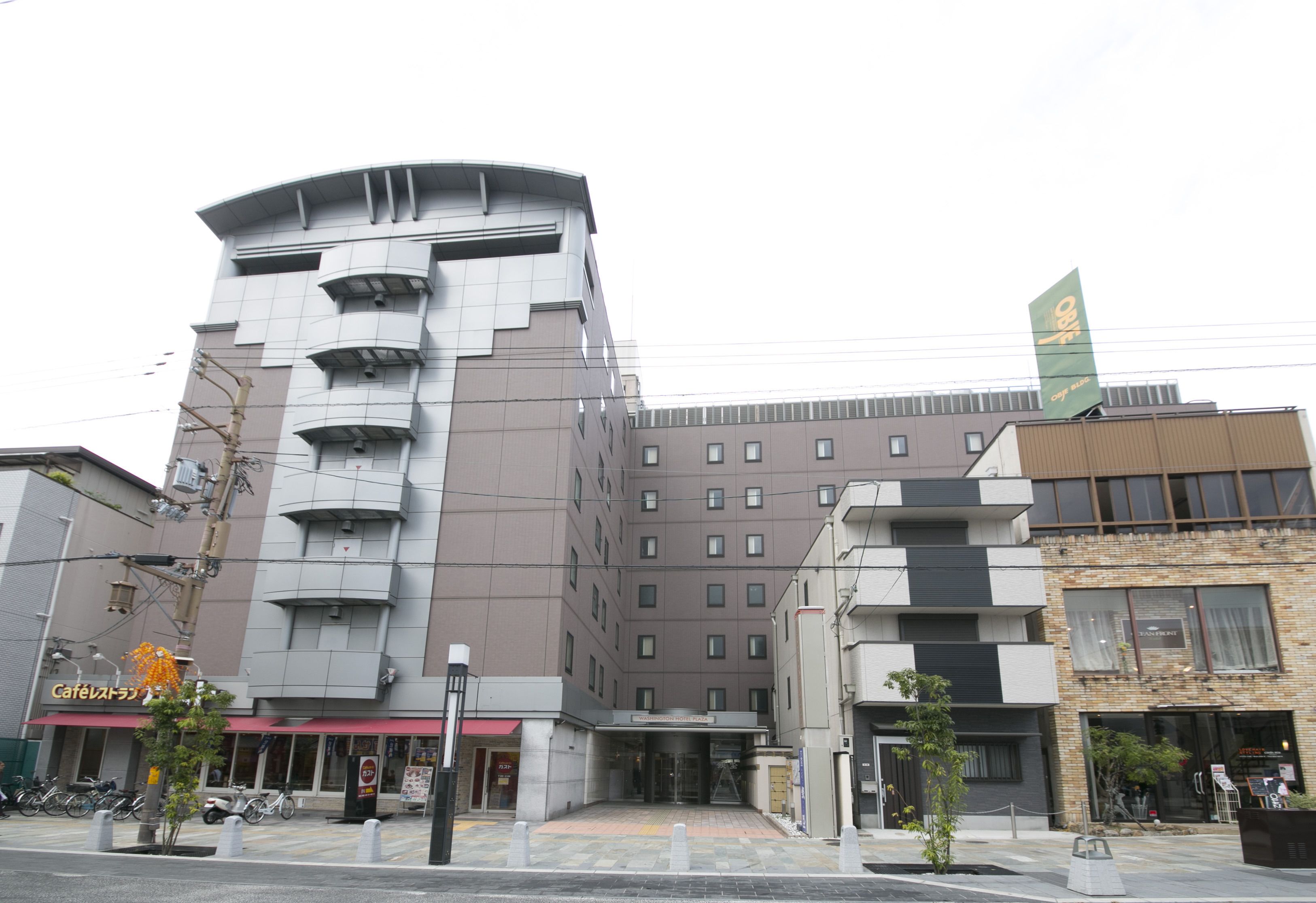 Un hôtel moderne à la façade incurvée, doté de plusieurs étages et d’une entrée imposante.