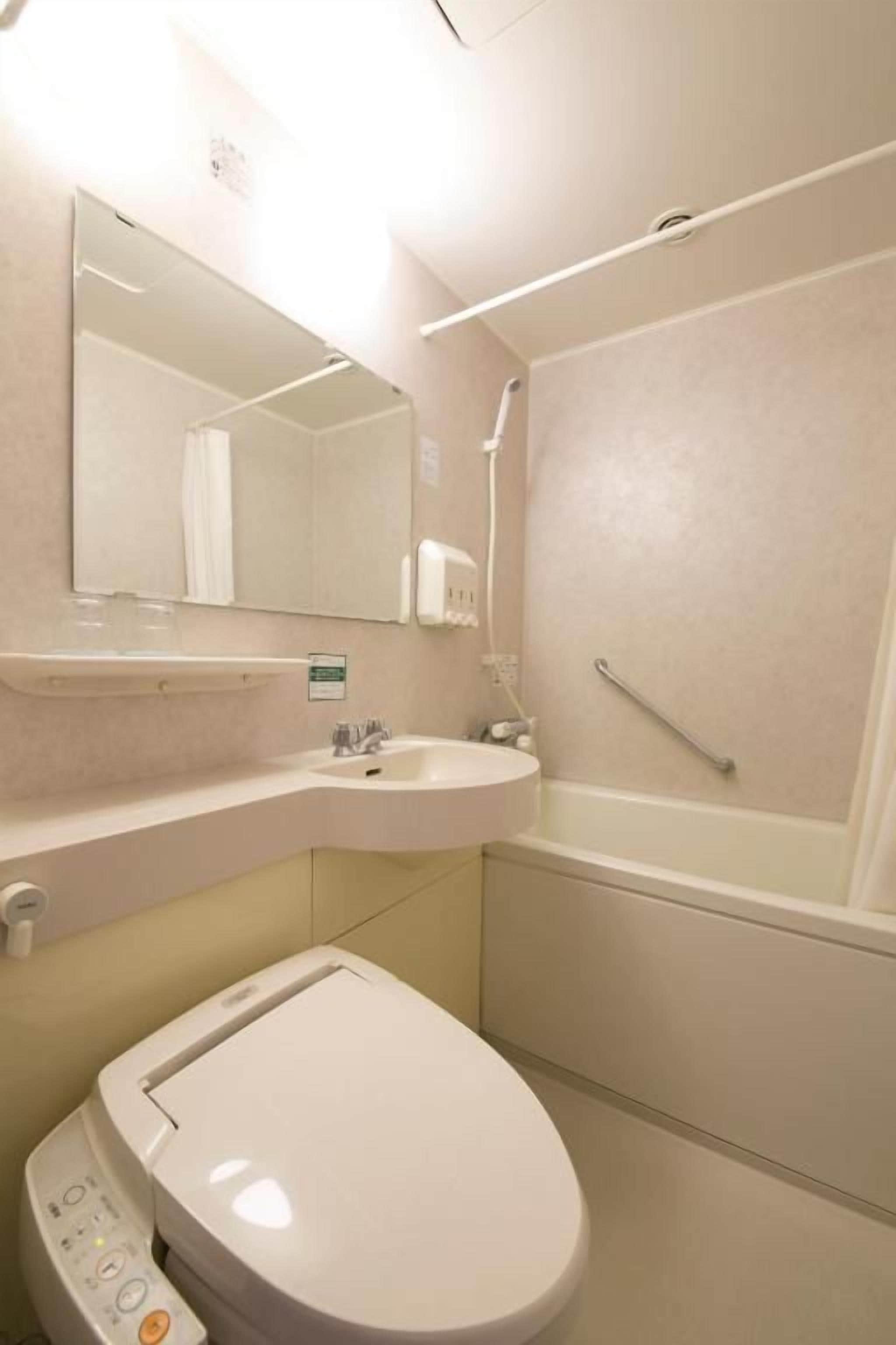 A bathroom with a toilet, sink, and bathtub.