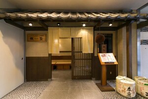 Un interior japonés tradicional con suelo de tatami, un shoji y un cartel.