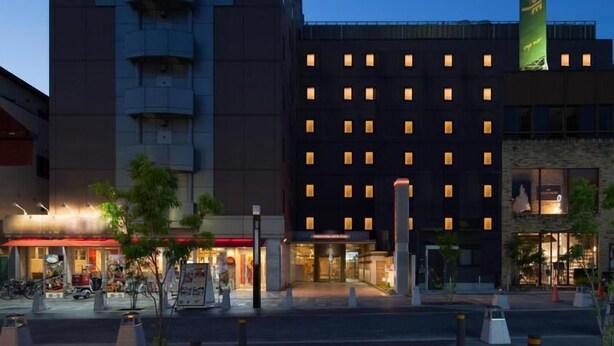 A hotel with a modern design, featuring a prominent curved structure and a flat-roofed building with evenly spaced windows. - Nara Washington Hotel Plaza (Nara)