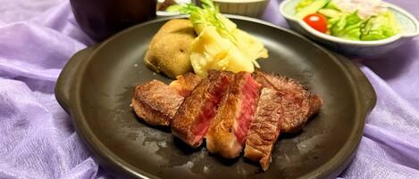 Un plato con bistec, puré de papas y una ensalada.