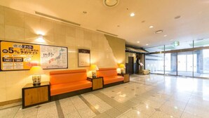 A hotel lobby with a reception area, orange seating, and a large informational poster on the wall. - Nara Washington Hotel Plaza (Nara)