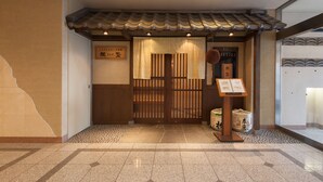 A traditional Japanese entrance with a tiled roof, wooden doors, and a signboard. - Nara Washington Hotel Plaza (Nara)