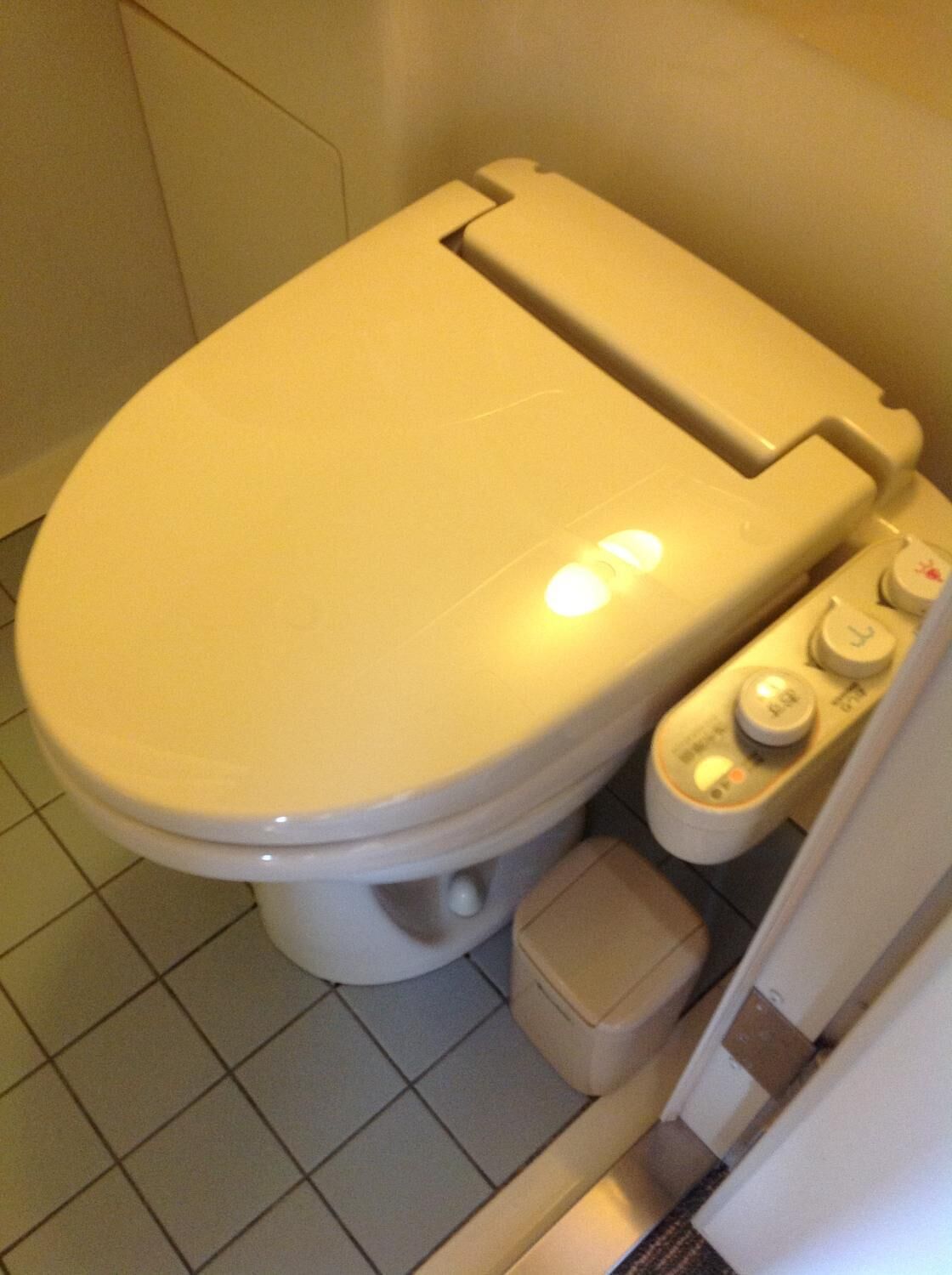 Un inodoro con asiento elevado y un bidé incorporado.