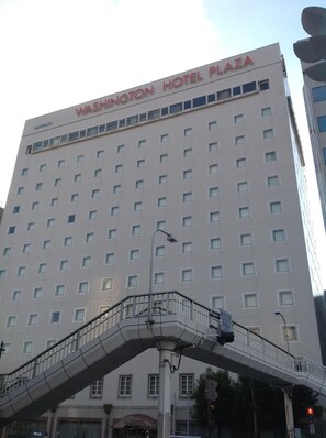 Een hoog gebouw met het bord "Washington Hotel Plaza" bovenop.