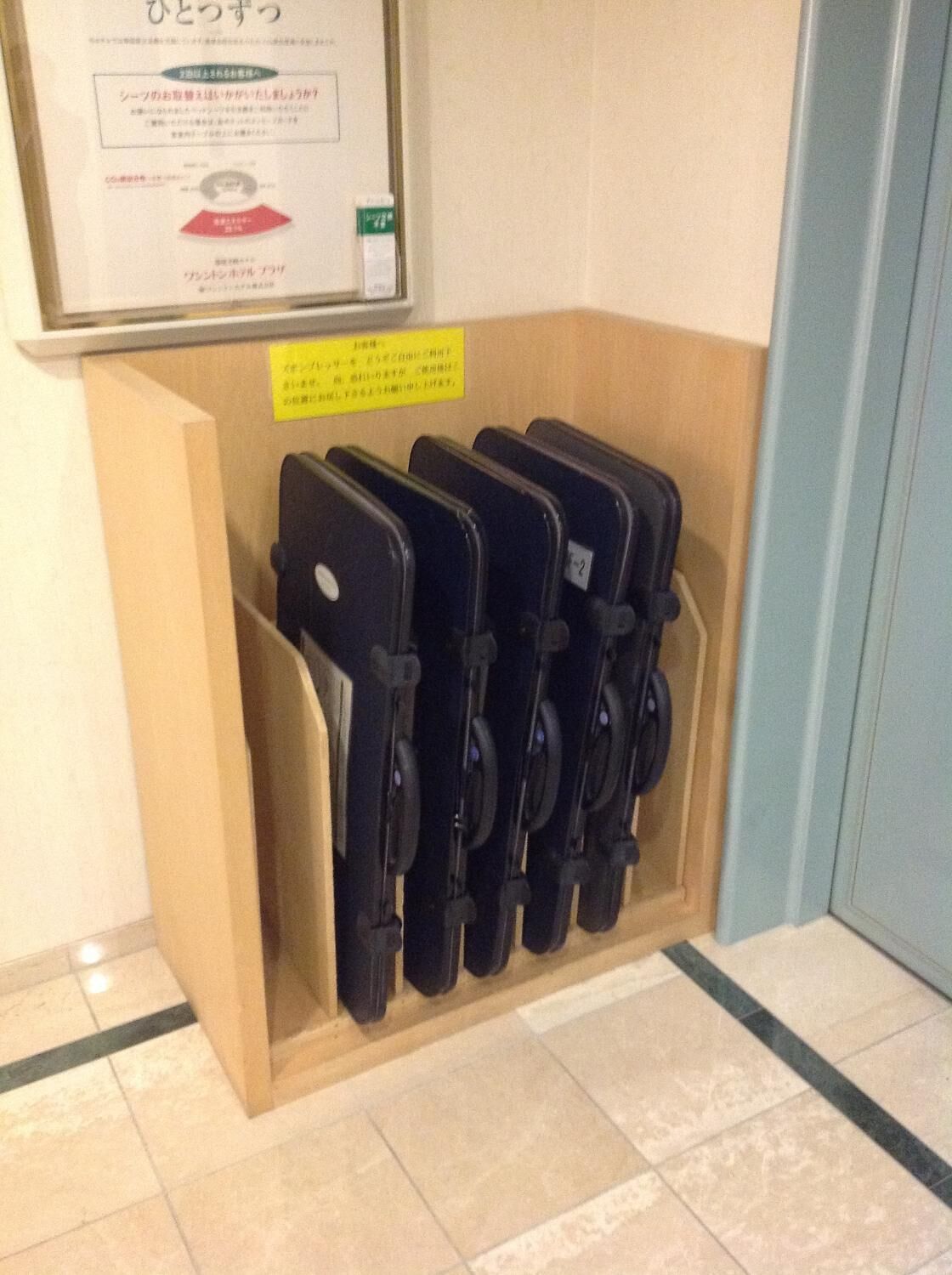 A storage unit with black luggage racks holding several suitcases.
