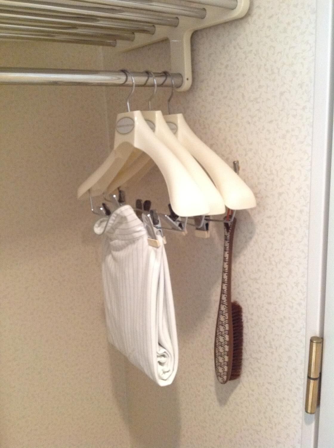 Baño con toallero que sostiene una toalla doblada y un cepillo para el cabello.