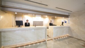 A reception area with marble counters, a flat-screen TV, and a digital display.
