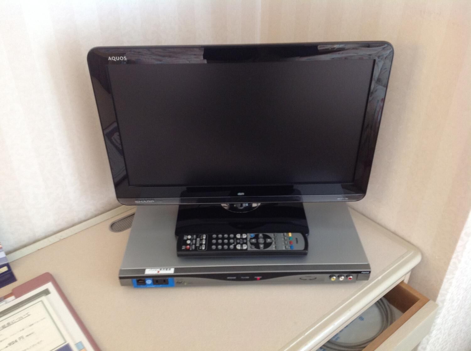 A flat-screen TV on a stand with a remote control.