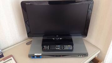 A flat-screen TV on a stand with a remote control.