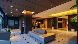 A modern lobby with a sofa, seating area, and reception desk.