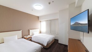 Une chambre d’hôtel avec deux lits, une télévision et une vue sur la montagne et la mer.