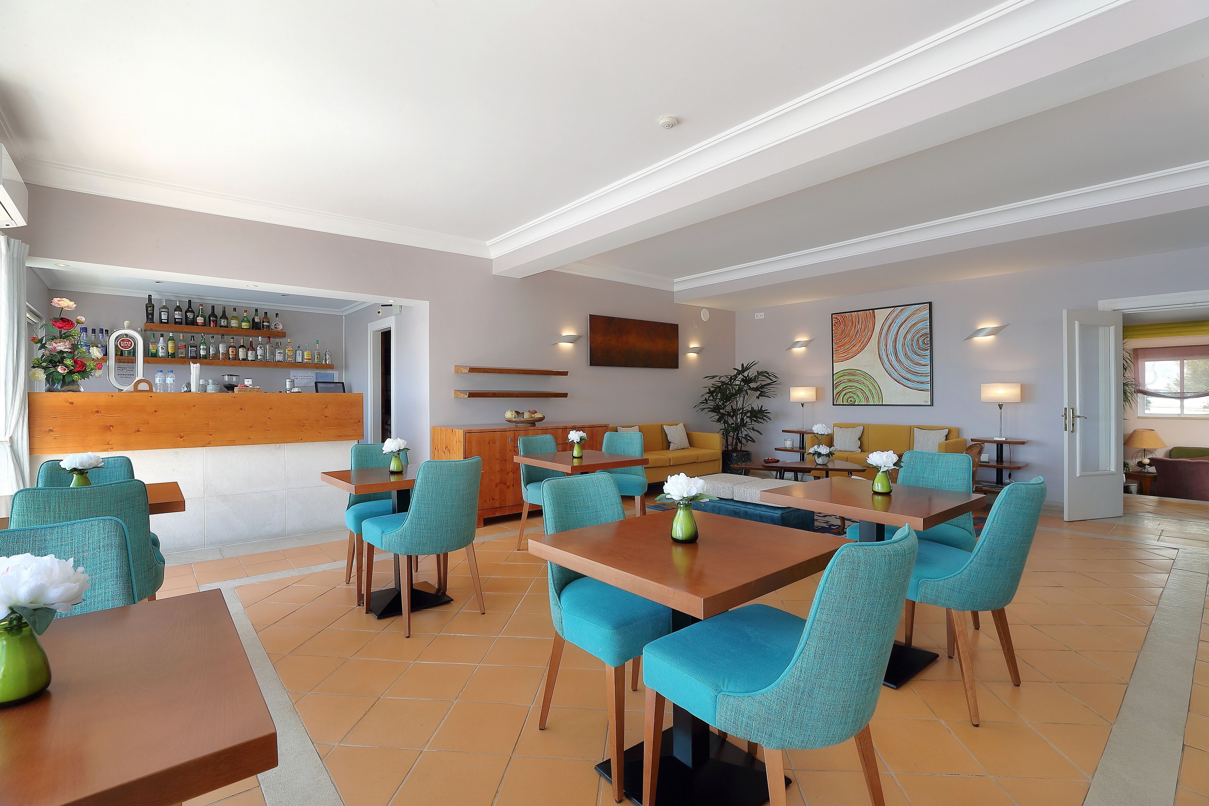 A modern hotel lobby with a bar area, seating arrangements, and a dining section.