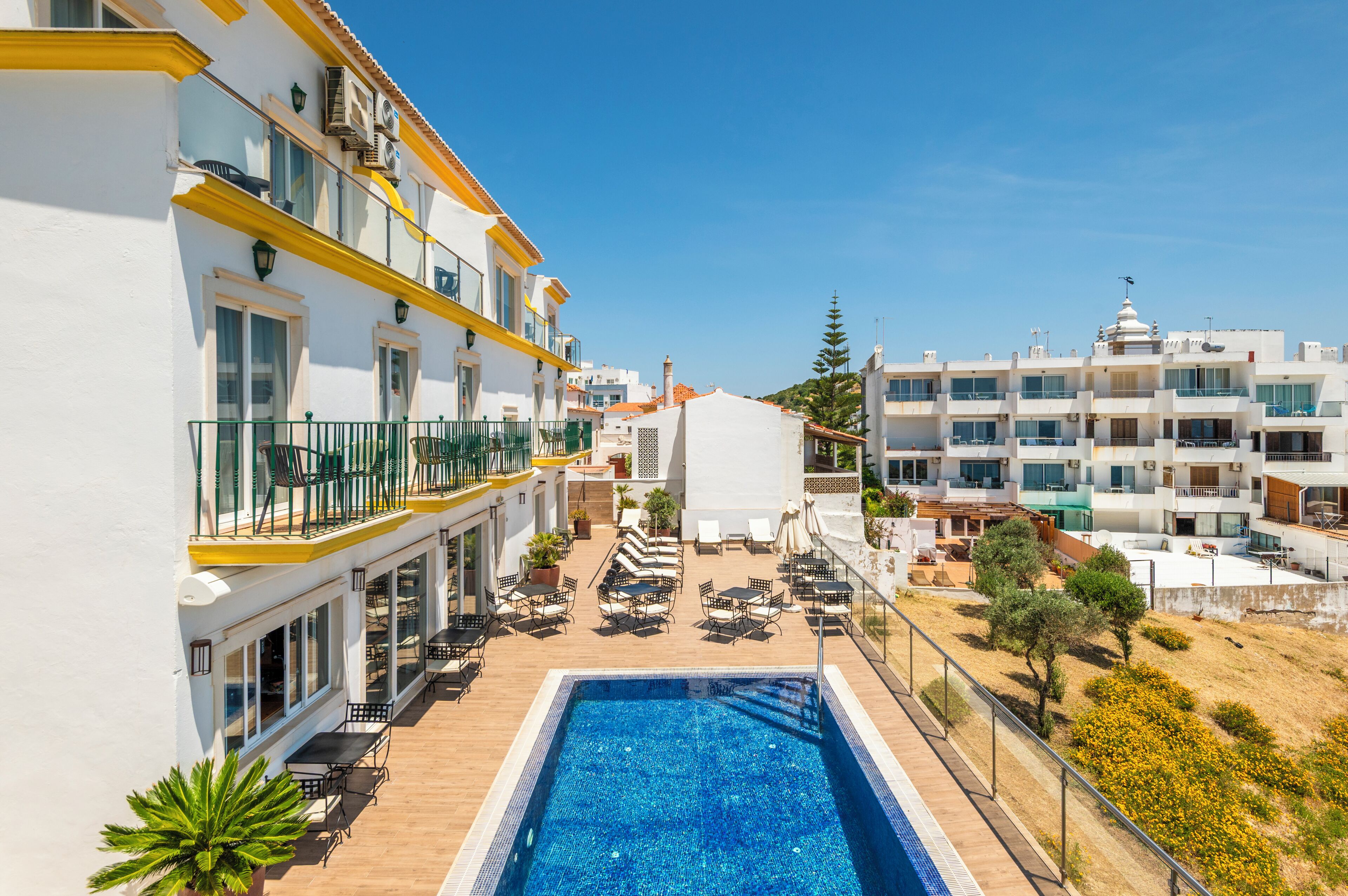 Un hôtel doté d’une piscine, d’un espace extérieur aménagé et de plusieurs balcons.