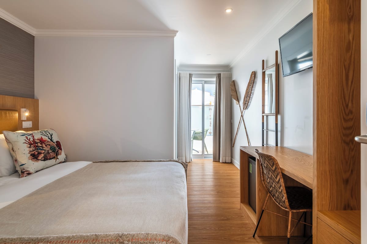 Une chambre à coucher avec un lit, un bureau et un téléviseur.