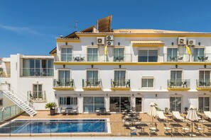 A multi-story hotel with balconies, a swimming pool, and outdoor seating. - Vila São Vicente - Adults Only (Albufeira)