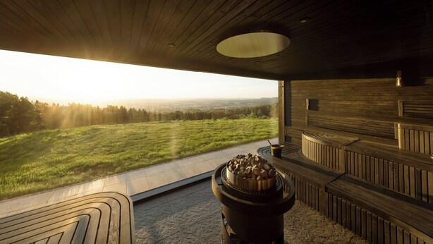 A modern interior with a large window overlooking a grassy field. - Burghotel Staufeneck (Salach)