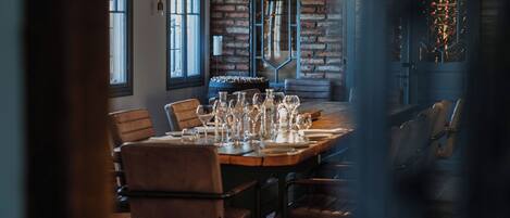 A dining area with a long table set for multiple people, chairs, and a hanging light fixture.
